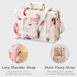 May include: A pink and white vintage-style suitcase handbag with a white shoulder strap and a short, brown strap. The handbag has a printed design of women and a dog. The text "on you and me of the world Beautiful" is printed on the front of the bag.