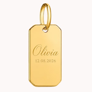 Peut inclure: Un pendentif rectangulaire doré poli aux coins arrondis et à l'orientation verticale. La surface est gravée du prénom Olivia dans une police cursive, suivi de la date numérique 12.08.2026. Une bélière dorée est fixée au sommet.