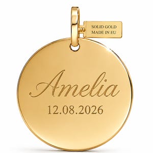以下が含まれることがあります： 名前「Amelia」と日付「12.08.2026」が刻印された円形のゴールドペンダント。上部のバチカンには「SOLID GOLD MADE IN EU」と刻印された小さな長方形のタグが付いています。ペンダントは光沢のある反射面を備えています。