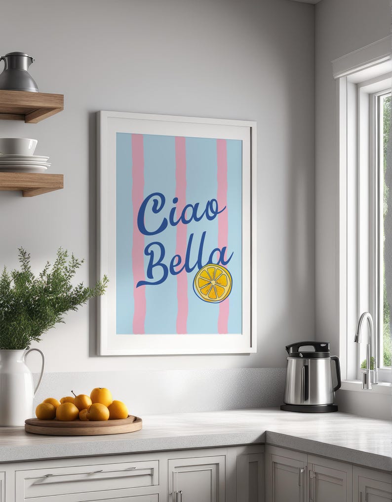 May include: A white framed print with a blue and pink striped background. The print says "Ciao Bella" in blue cursive lettering with a yellow lemon slice graphic.