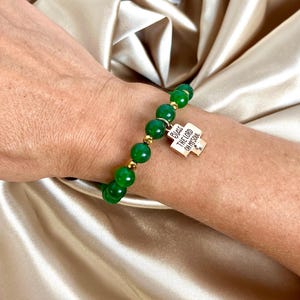 Könnte beinhalten: Ein Armband aus grünem Jade-Stein mit goldenen Perlen und einem goldenen Anhänger mit der Aufschrift "Bless the Lord Oh My Soul".