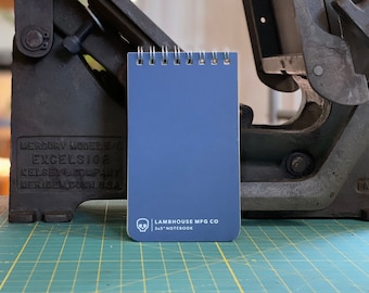 May include: A blue 3x5 inch notebook with a skull logo and the text "LAMBHOUSE MFG CO" on the cover.