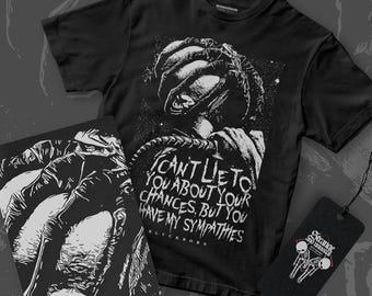 May include: Black and white graphic t-shirt featuring a creature with the text "I can't lie to you about your chances, but you have my sympathies" and the word "Blackborn" below. The t-shirt is paired with a black and white graphic print on a notebook and a black tag with the text "Strange and Unusual" and a graphic of two skeletons.