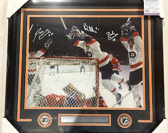 LBC Line Reggie Leach, Bill Barber, Bobby Clarke Autograph Signed Flyers 16x20 Photo black framed black over orange matting PSA