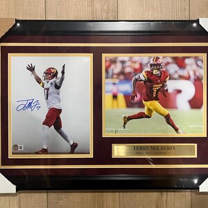 May include: Framed photo print featuring two action shots of a football player in a burgundy and gold uniform. One image shows the player with arms raised, the other shows him running. The print includes a gold nameplate.