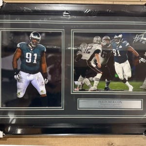 May include: Framed double photo of an American football player in a teal and white uniform, number 91. The frame is black with a silver nameplate that reads "FLETCHER COX". The photos show the player in action on the field.