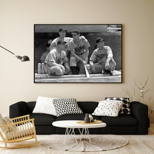 May include: Black and white photograph of four baseball players in uniform, sitting on a bench. The players are wearing caps and jerseys with the word "Rays" on them. The photo is framed in a black frame.