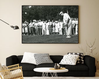 Pode incluir: Fotografia a preto e branco de um golfista a balançar um taco num campo de golfe. O golfista está rodeado de espectadores a assistir ao jogo.