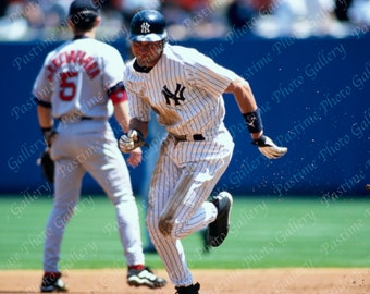 Puede incluir: Un jugador de béisbol con un uniforme a rayas blancas y azules corre hacia el home plate. El jugador lleva una gorra de béisbol con el logotipo de los New York Yankees. El jugador lleva un uniforme a rayas blancas y azules con el número 10 en la espalda. El jugador corre hacia el home plate con un bate de béisbol en la mano.
