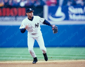 Puede incluir: Un jugador de béisbol con un uniforme a rayas blancas y azules con el logotipo de los New York Yankees en el pecho, corre hacia la cámara con un guante de béisbol en la mano derecha.