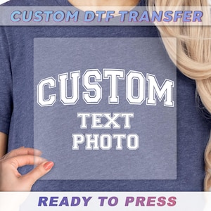 a woman holding up a t - shirt that says custom text photo