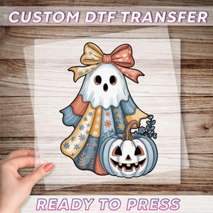 Peut inclure: Transfert DTF avec un fantôme de dessin animé avec un nœud, des vêtements en patchwork et une citrouille d'Halloween. Le fantôme est blanc avec des yeux noirs et une bouche souriante. Le texte "CUSTOM DTF TRANSFER" et "READY TO PRESS" est également inclus.