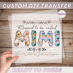 May include: A white heat transfer design with the text "Blessed to be called Mimi" in colorful floral letters. Below the text are the names Olivia, Alex, John, and Sophia with butterfly icons.