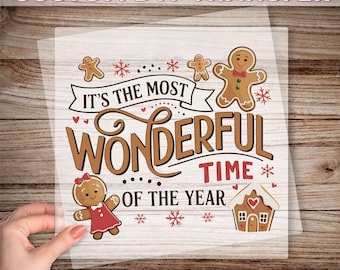 May include: A clear DTF transfer sheet with the text "CUSTOM DTF TRANSFER" at the top and "READY TO PRESS" at the bottom. The design features gingerbread people, snowflakes, and the phrase "IT'S THE MOST WONDERFUL TIME OF THE YEAR."