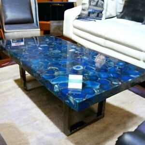 May include: A blue agate coffee table with a polished, glossy finish. The table has a rectangular top and a black metal frame.
