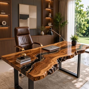 Puede incluir: Un escritorio de madera con borde natural, una incrustación central de resina negra y acabado brillante, sostenido por patas de metal negro en forma de U. La superficie muestra vetas de madera prominentes y bordes irregulares, junto a una silla de cuero.