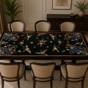 Pode incluir: Uma mesa de jantar retangular preta com um design incrustado intrincado de pássaros coloridos e padrões florais na superfície, rodeada por seis cadeiras estofadas com assentos de tecido bege e estruturas de madeira escura.