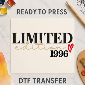 Könnte beinhalten: Cremefarbener DTF-Transfer mit den Worten "LIMITED edition 1996" in schwarzer und beiger Schrift, mit einem roten Herz. Die Wörter "READY TO PRESS" und "DTF TRANSFER" werden ebenfalls angezeigt.