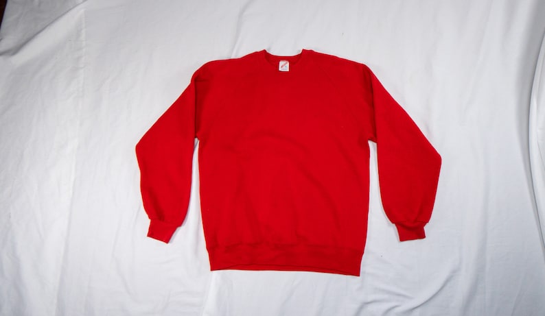 May include: A solid red sweatshirt with a crew neck.