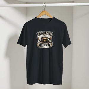 May include: A black short-sleeved t-shirt featuring a central graphic of a steaming coffee cup on a saucer. The text "ESPRESSO YOURSELF" is printed in a bold, arched font above and below the cup, accented by lightning bolt icons.