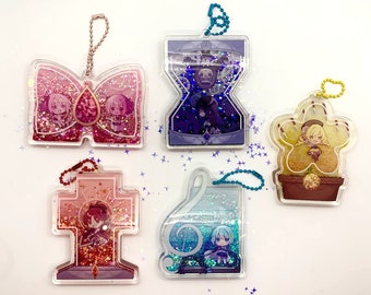 May include: Five colorful resin keychains with glitter and anime characters. Each keychain features a different character and design, including a bow, a cross, a flower, a music note, and an hourglass.