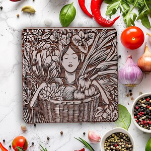 May include: A wooden cutting board with an engraved design of a woman holding a basket of vegetables. The design is in shades of brown and white. The board is surrounded by various vegetables, herbs, and spices.