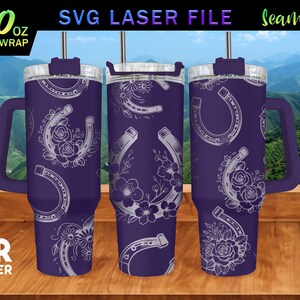 May include: A purple 40 ounce tumbler with a white horseshoe and floral design. The tumbler has a lid and a handle. The text "40 oz FULL WRAP" is visible in the image.