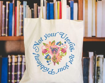 Bolsa de yute con mensaje feminista "Si no es tu útero, no es tu problema", bolsa de algodón, bolsa de algodón política con estampado de flores silvestres de colores.