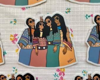 Könnte beinhalten: Vier Frauen in traditioneller indigener Kleidung mit bunten Mustern und Perlen. Sie lächeln alle und schauen in die Kamera. Die Frauen tragen Sonnenbrillen und haben langes schwarzes Haar. Der Hintergrund ist ein weißer Stoff mit Blumenmuster.