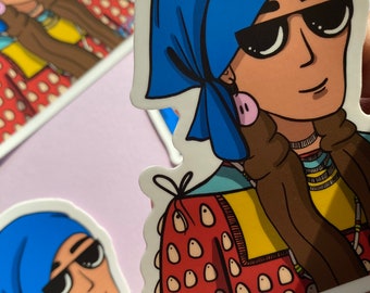 Puede incluir: Una pegatina con una ilustración de dibujos animados de una persona que lleva un pañuelo azul, gafas de sol y una chaqueta con estampado rojo y amarillo. La persona tiene la piel morena y pendientes rosas.