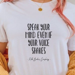 May include: White t-shirt with the quote "Speak your mind. Even if your voice shakes" attributed to Ruth Bader Ginsburg.
