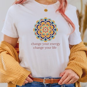 Puede incluir: Camiseta blanca con un diseño de mandala colorido y el texto "change your energy change your life".