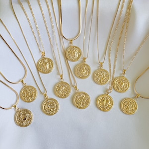 Puede incluir: Doce collares de oro con s&iacute;mbolos del zod&iacute;aco en colgantes redondos. Cada colgante presenta un signo del zod&iacute;aco diferente.