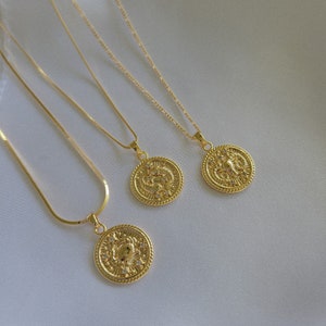 Puede incluir: Tres collares de oro con colgantes circulares que presentan dise&ntilde;os intrincados y peque&ntilde;as piedras brillantes. Los colgantes son diferentes, pero todos tienen un estilo similar.