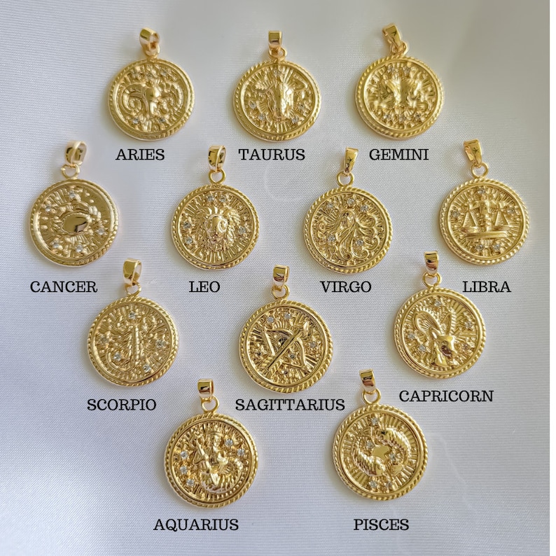 Puede incluir: Doce colgantes de oro del zod&iacute;aco con cristales blancos. Cada colgante presenta un signo del zod&iacute;aco diferente: Aries, Tauro, G&eacute;minis, C&aacute;ncer, Leo, Virgo, Libra, Escorpio, Sagitario, Capricornio, Acuario y Piscis.