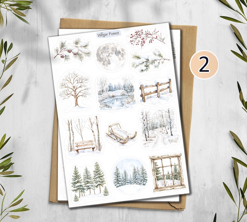 May include: A sheet of winter-themed stickers featuring watercolor illustrations of snowy landscapes, trees, and a full moon. The stickers include a bench, a sled, and a wooden fence. The text "Winter Forest" is visible on the top of the sheet.