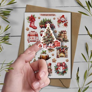 May include: A sticker sheet titled Traditional Christmas featuring watercolor illustrations of a red stocking, a truck with pine trees, a snowman, a patterned sweater, a decorated Christmas tree, gift boxes, a fireplace, a pudding, and a wreath.