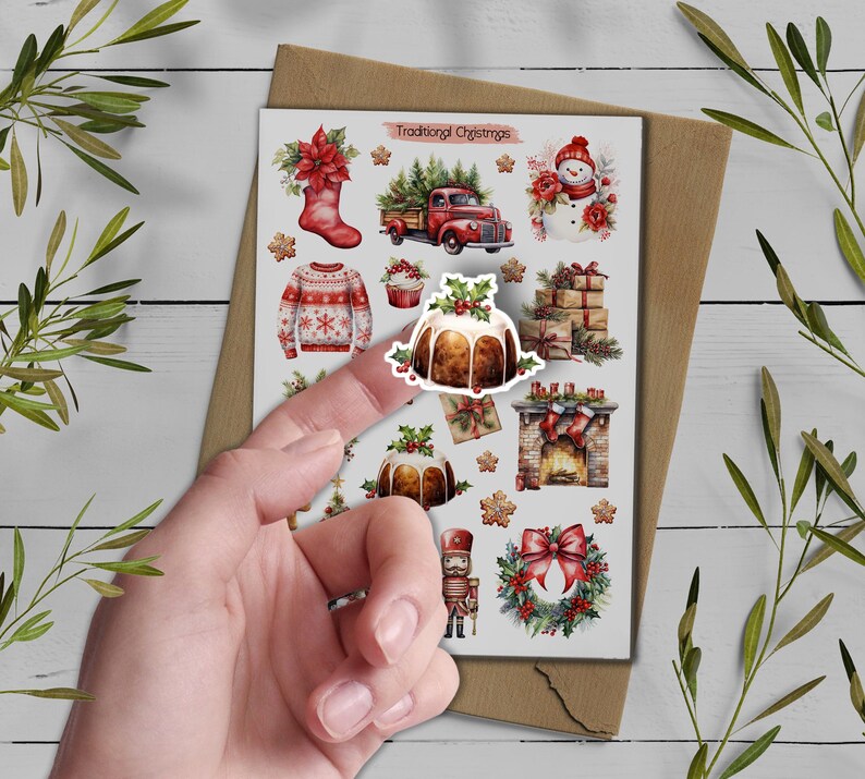 May include: A sticker sheet titled Traditional Christmas featuring watercolor illustrations of a red stocking, a red truck with trees, a snowman, a sweater, a Christmas pudding, wrapped gifts, a fireplace, a nutcracker, and a wreath.
