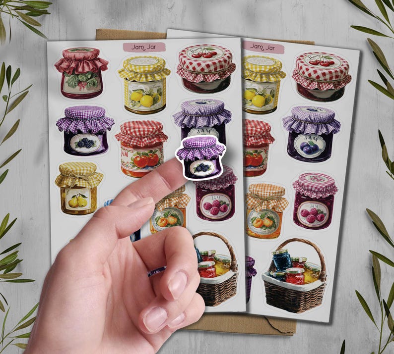 May include: A sheet of stickers featuring various jam jar designs. The jars have different colored lids and labels, with illustrations of fruits like cherries, lemons, and berries. Some stickers are in baskets.