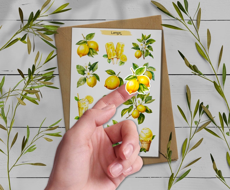 May include: A sheet of stickers featuring watercolor illustrations of lemons, lemon trees, lemon popsicles, and a glass of lemonade. The stickers are on a brown background and the text "Lemon" is at the top of the sheet.