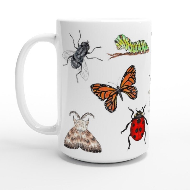 K&ouml;nnte beinhalten: Wei&szlig;e Keramiktasse mit einer bunten Illustration verschiedener Insekten, darunter ein Schmetterling, ein Marienk&auml;fer, eine Raupe, ein Falter und eine Fliege.