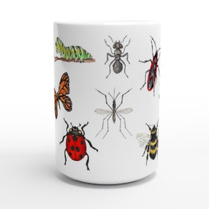 K&ouml;nnte beinhalten: Wei&szlig;e Keramiktasse mit einem bunten Insekten-Design. Die Tasse zeigt einen Schmetterling, einen Marienk&auml;fer, eine Raupe, eine Biene, eine M&uuml;cke und zwei weitere Insekten.