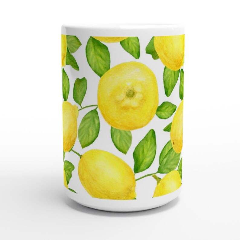 K&ouml;nnte beinhalten: Wei&szlig;e Keramiktasse mit einem sich wiederholenden Muster aus gelben Zitronen und gr&uuml;nen Bl&auml;ttern.