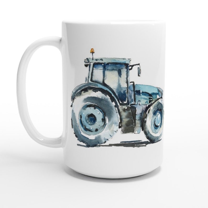 K&ouml;nnte beinhalten: Eine wei&szlig;e Keramiktasse mit einer Aquarell-Illustration eines blauen Traktors. Der Traktor hat gro&szlig;e R&auml;der und ein detailliertes Design.