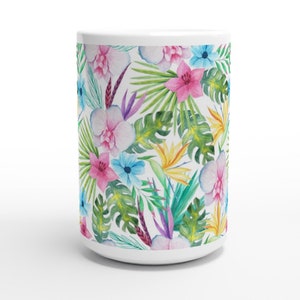 May include: White ceramic mug featuring a tropical floral design. The pattern includes pink, purple, blue, and yellow flowers with green leaves.