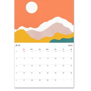 May include: A July 2025 calendar with a colourful abstract design featuring a white sun and yellow, orange, and teal mountains. The calendar is printed on white paper.