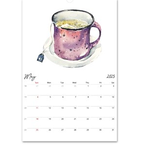Peut inclure: Une page de calendrier mural pour mai 2025 pr&eacute;sentant une illustration &agrave; l'aquarelle d'une tasse violette mouchet&eacute;e remplie de th&eacute; sur une soucoupe blanche, avec une &eacute;tiquette de sachet de th&eacute; suspendue sur le c&ocirc;t&eacute;. La grille affiche les jours.