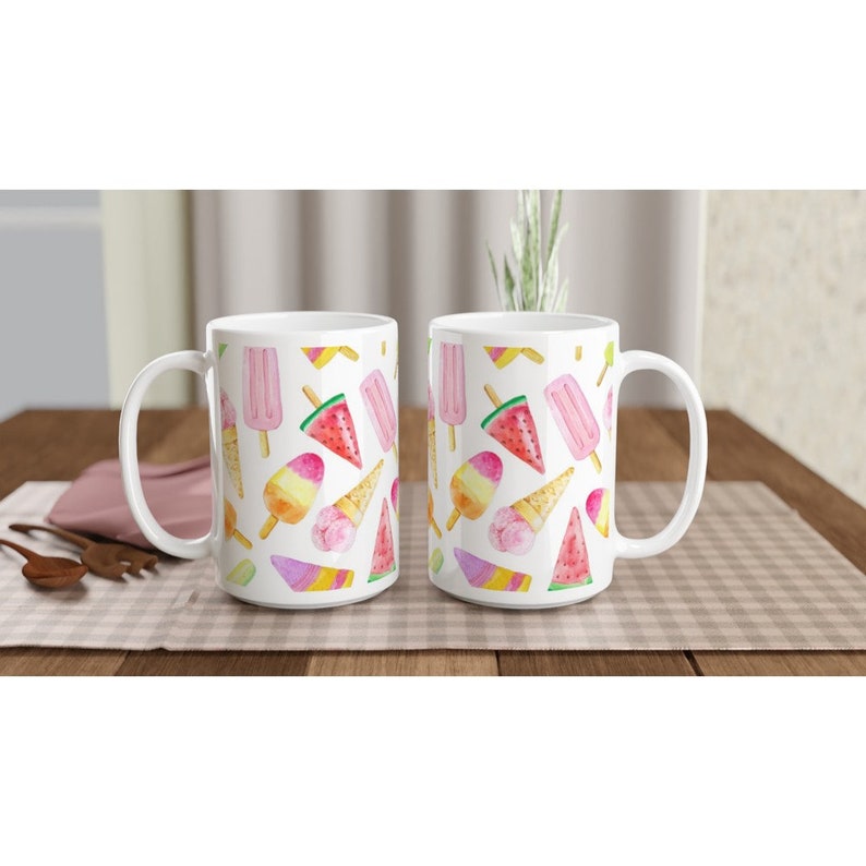 May include: Two white ceramic mugs with a summery ice cream and watermelon pattern. The mugs have a white background with colorful illustrations of ice cream cones, popsicles, and watermelon slices.