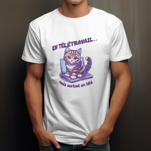 Könnte beinhalten: Weißes T-Shirt mit einer Cartoon-Katze auf einem Laptop. Die Katze ist braun und orange. Der Text auf dem Shirt lautet "EN TÉLÉTRAVAIL... mais surtout en télé".