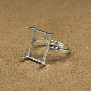 Op de afbeelding: Zilveren ring met een rechthoekige bezel-setting. De ring is ontworpen om een ​​edelsteen of ander materiaal te bevatten.